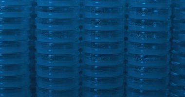 Mavi ışıklandırmalı bir laboratuvar odasında petrol kapları üst üste yığılmış. Yavaş çekim, sola dön, yaklaş. Bmpcc 4K ile. Biyokimya, ilaç, bilim konsepti.