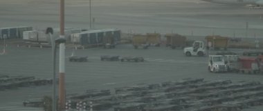Gün batımında havaalanının pistinde küçük bir servis bagaj vagonu süren adam, Bmpcc 4k - sinematik ağır çekim. Yumuşak hareket, kontrol edildi, uzun atış..