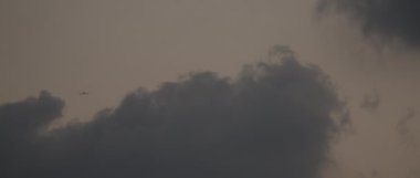 Gün batımında bulutlara doğru uçan bir uçak. Ağır çekim, Bmpcc 4k. Boşluğu kopyala