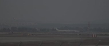 Gün batımında havaalanının pistine inmeye hazırlanan uçak, yavaş çekim Bmpcc 4k