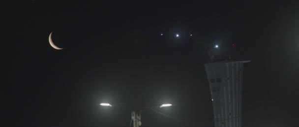 飞机在月亮和飞机场塔楼的旁边飞入夜空 慢动作Bmpcc — 图库视频影像