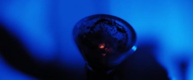 Sinemaya yakın çekim, esrar yakma, nargile tüttürme süreci, yavaş çekim, koyu mavi oda ışıklandırması, sığ alan derinliği, güzel bokeh. Bmpcc 4k