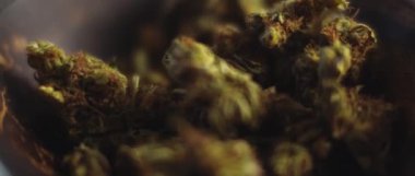 Kenevir tomurcuklarını bir kaseye koy, sığ bir alan derinliği, yavaş çekim, Bmpcc 4k. Marihuana, ot, sigara konsepti. Cbd, Thc görüntüleri