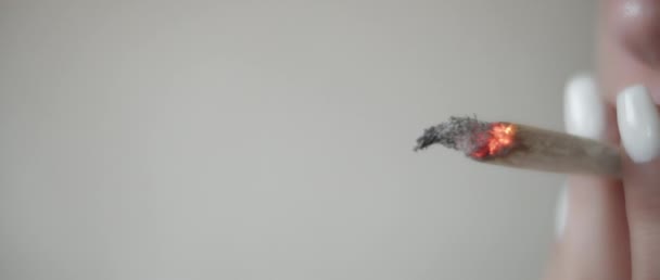 Gros plan d'une femme fumant un joint de cannabis, au ralenti. BMPCC 4K. Marijuana, weed, smoking drugs concept. CBD, séquences THC 