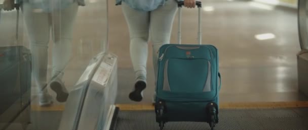 Frau Mit Türkisfarbenem Koffer Verlässt Rolltreppe Und Setzt Ihre Reise — Stockvideo