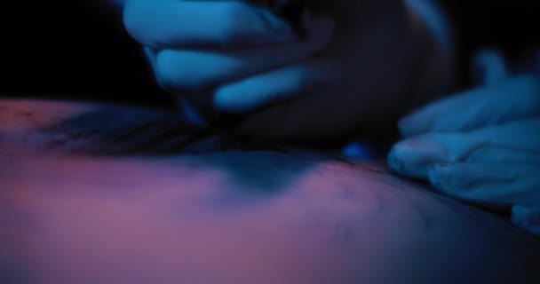 入れ墨マスターは 人の体 マクロに入れ墨 スローモーション 青のスタジオ照明 フィールドの浅い深さ Bmpcc — ストック動画