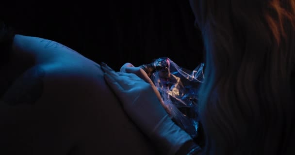 女性のタトゥーアーティストの閉じる人の背中に入れ墨を描く スローモーション 青のスタジオ照明 フィールドの浅い深さ Bmpcc — ストック動画