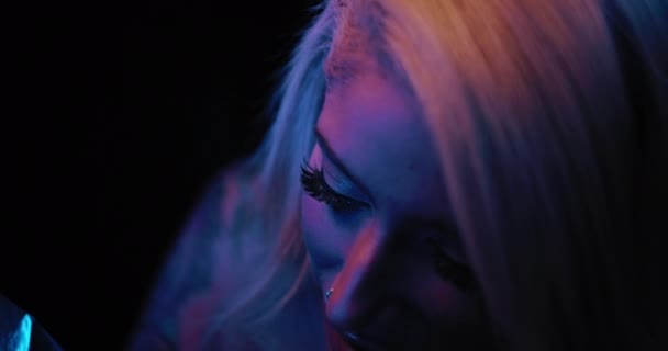 若い女性のタトゥーアーティストは 人の体に入れ墨を描くことをしながら笑顔 スローモーション 青のスタジオ照明 フィールドの浅い深さ Bmpcc — ストック動画