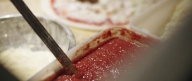 Aşçı geleneksel İtalyan pizzasına peynir, domates sosu ve taze fesleğenle mantar ekliyor. Ağır çekim, Blackmagic Tasarım Cep Kamerası 4k