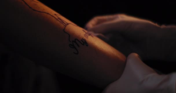 Tatoueur préparant un dessin sur la main d'une personne pour le tatouage. Gros plan, mouvement lent, faible profondeur de champ. BMPCC 4K 