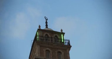 Gün batımı manzarası, arkaplanında mavi gökyüzü olan Müslüman cami minaresinin tepesi, alçak açı, alt manzara, Bmpcc 4k