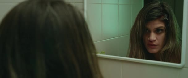 Молодая Женщина Глядя Зеркало Обнаруживает Идет Кровь Головы Страшно Концепция — стоковое видео