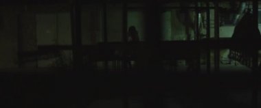 Zombi kadın gece binanın yakınından geçiyor. Kadın zombiye dönüşümü. Korku filmi tarzı çekim. El bilgisayarı, sinematik görünüş. BMPCC 4K