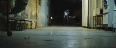 Zombi kadın geceleri binalar arasındaki geçitte yürüyor. Kadın zombiye dönüşümü. Korku filmi tarzı çekim. El bilgisayarı, sinematik görünüş. BMPCC 4K