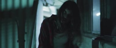 Zombi kadın gece yarısı binanın dışında yürüyordu. Kadın zombiye dönüşümü. Korku filmi tarzı çekim. El bilgisayarı, sinematik görünüş. BMPCC 4K