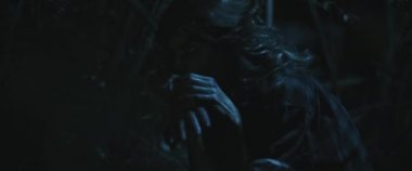 Korkunç zombi yaratık kadın ormanda insan eli yiyor. Kapatın. Kadın zombiye dönüşümü. Korku filmi tarzı çekim. Yakın çekim, el kamerası, sinematik görünüş. BMPCC 4K
