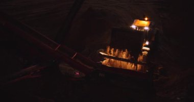 Ön yükleme kamyonu parlayan ışıklarla inşaat alanındaki taş öğütücüye naklediliyor. Yavaş çekim, endüstriyel ekipman konsepti. BMPCC 4K