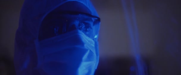 マスクとメガネで保護スーツの男の閉じると 周りを見回す 健康と安全の生活 ウイルス保護 パンデミックの概念 ブルーライト スローモーション Bmpcc — ストック動画