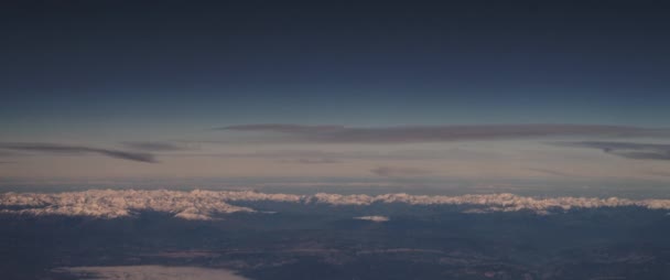 雪の山の峰と美しい空の空中ビュー 飛行機の窓から見る 旅のコンセプト スローモーション Bmpcc — ストック動画