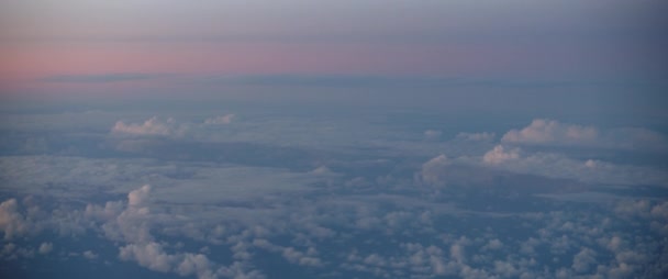 日没時の雲とスカイラインの美しい景色 飛行機の窓から見る 旅のコンセプト スローモーション Bmpcc — ストック動画