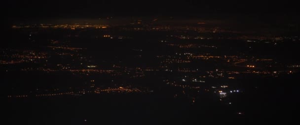 夜の飛行機の窓から街の空中ビュー 夜間に道路や建物の上を飛ぶ飛行機 旅のコンセプト スローモーション Bmpcc — ストック動画