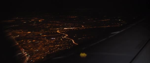 Vue aérienne de la ville depuis la fenêtre de l'avion la nuit. Avion volant au-dessus des routes et des bâtiments la nuit. Aventure, voyage, concept de voyage. MOTION DE LENT, BMPCC 4K . 