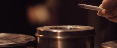 Kadın kül tablasına sigara külleri atıyor. Güzel bir duman perdesi. Sigara içmek, sağlıksız bir kavram. Yaklaş, Yavaş Hareket, Kısık Dof, BMPCC 4K. 