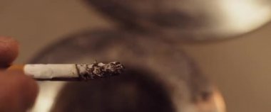 Adam kül tablasına sigara külleri atıyor. Sigara içmek, sağlıksız bir kavram. Yaklaş, Yavaş Hareket, Kısık Dof, BMPCC 4K. 
