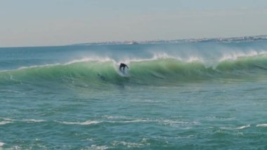 Büyük mavi bir dalgayı yakalarken suya düşen sörfçü. Macera sörfü yaşam tarzı. Ağır çekim, BMPCC 4K.