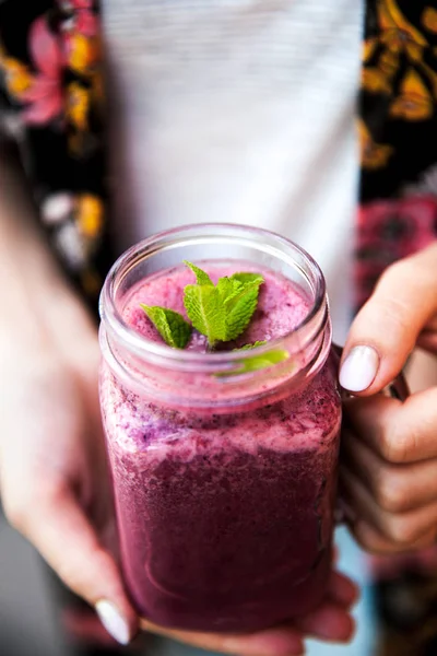 Tutup tangan wanita dengan warna fashion kuku memegang es dingin smoothie berry campuran — Stok Foto