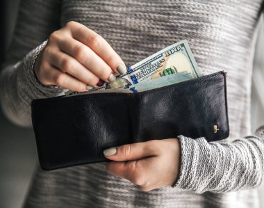 Bayan deri cüzdan yüz dolar bir tomar ile bağlı. İş teklifi. Güzel manikür