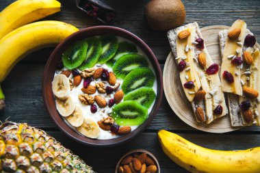 Yoğurt ahşap arka plan üzerinde farklı meyve ile. Yararlı gıda, beslenme, organik.