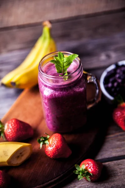 Blueberry smoothie pada latar belakang kayu dengan buah-buahan. Vitamin — Stok Foto