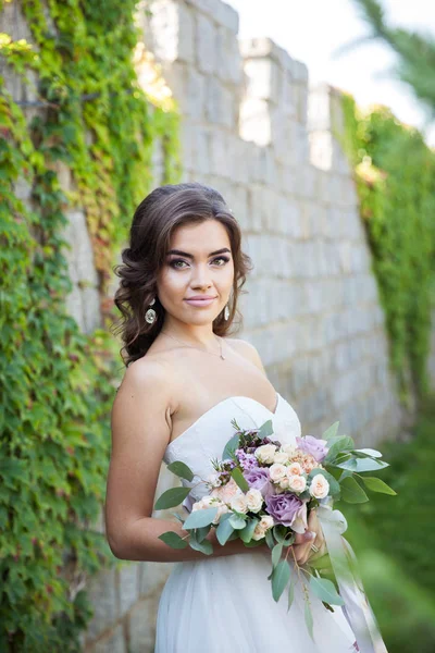 Bella giovane sposa con un mazzo di fiori da sposa. Abito da vacanza — Foto Stock