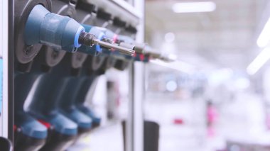 Seçici odak, fabrika fotokopi alanı arka planına sahip elektrikli tornavida setine yakın, kablosuz matkap tornavida sürücüsü.