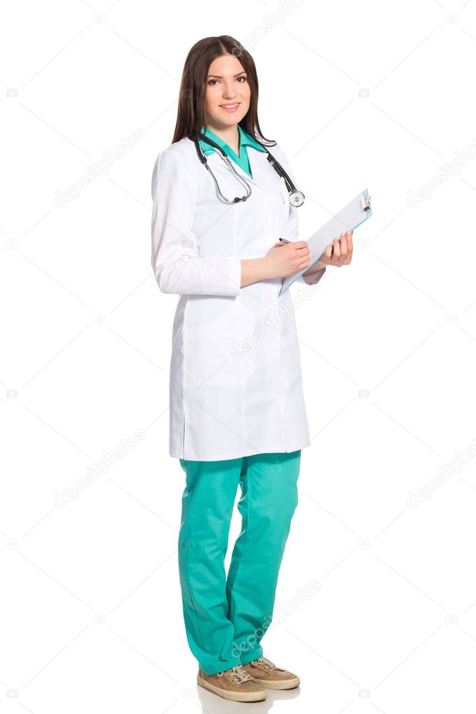 Female doctor in uniform with clipboard and stethoscope writting
