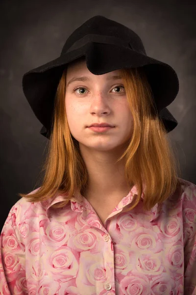 Elegante tiener meisje zwarte hoed dragen op donkere achtergrond. Jeugd mode. — Stockfoto