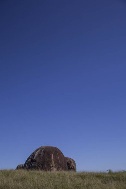 İkonik kaya yeşil çimen mavi gökyüzü.