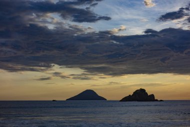 Gün batımında bir adası olan güzel Brezilya sahilleri senaryosu.