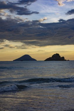 Gün batımında bir adası olan güzel Brezilya sahilleri senaryosu.