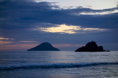 Gün batımında bir adası olan güzel Brezilya sahilleri senaryosu.