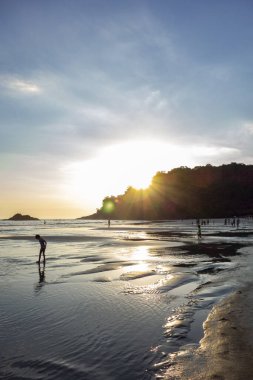 İnsanlar gün batımında plajda