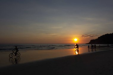 Gün batımında plajda insan aktiviteleri