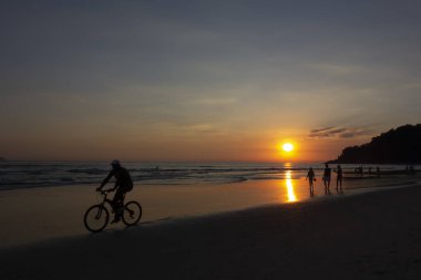 Gün batımında plajda insan aktiviteleri