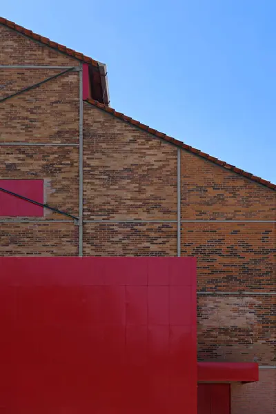 Détails architecturaux contrastés, vieux mur de briques, grande porte rouge — Photo