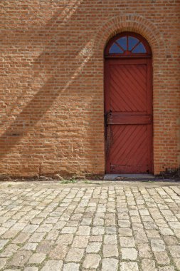 Kırmızı ahşap kapılı eski tuğla duvar