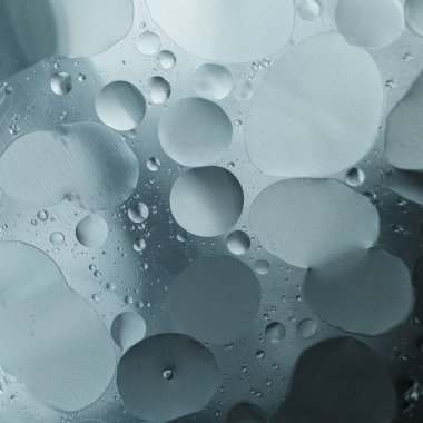 Gri metal arka planda suya yağ damlaları. Güzel soyut arkaplan.