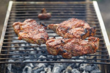 Açık ateşte ızgara biftek pişirme süreci.