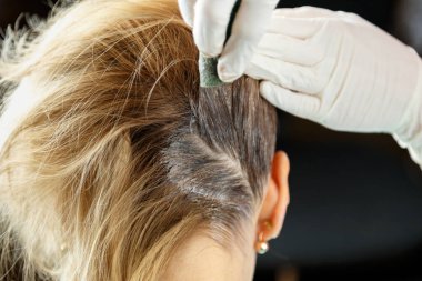 Kuaför kadın saçını bir güzellik salonunda boyadı..