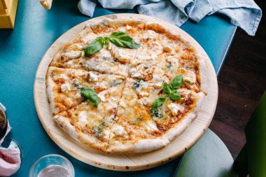 Tahta tepside dört peynirli pizza.